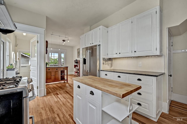 1707 W Resseguie St, Boise, ID 83702 - kitchen featuring appliances with stainless steel finishes, butcher block countertops, light wood-style flooring, white cabinets, and open shelves