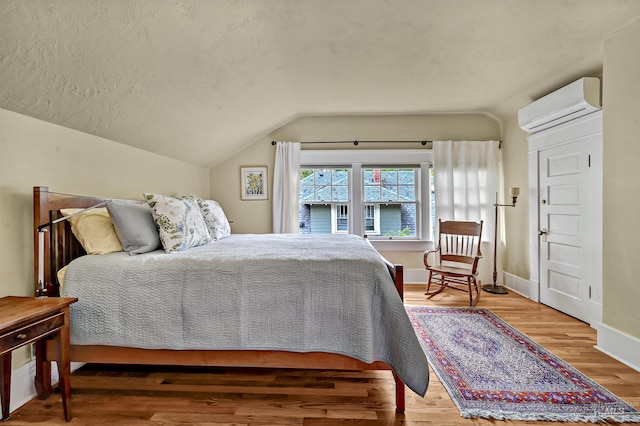 1707 W Resseguie St, Boise, ID 83702 - bedroom featuring a wall mounted AC, vaulted ceiling, and light wood-style flooring