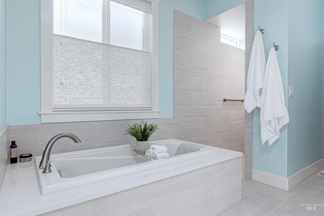 bathroom featuring a relaxing tiled tub and tile patterned flooring