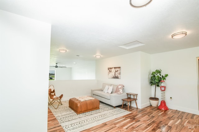 living room featuring a textured ceiling, ceiling fan, and light hardwood / wood-style flooring