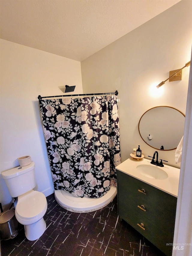 bathroom with walk in shower, vanity, and toilet