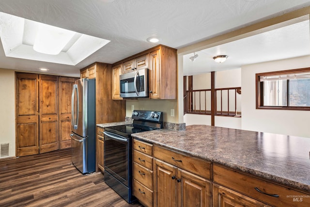 773 Monroe St, Twin Falls, ID 83301 - kitchen featuring stainless steel appliances, dark wood finished floors, recessed lighting, brown cabinets, and dark countertops