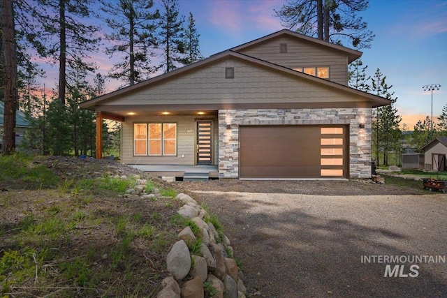 622 Woodlands Dr, Mccall, ID 83638 - view of front of home featuring stone siding, a porch, driveway, and a garage