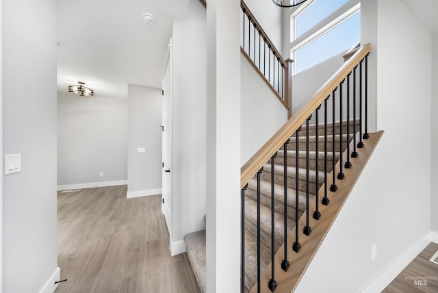 staircase with a high ceiling and hardwood / wood-style floors