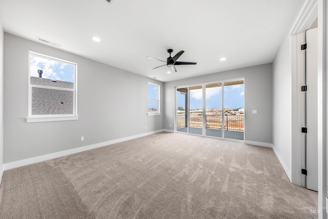 carpeted spare room featuring ceiling fan