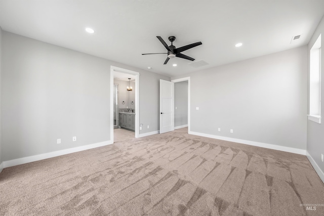 unfurnished bedroom with light carpet, ceiling fan, and ensuite bath