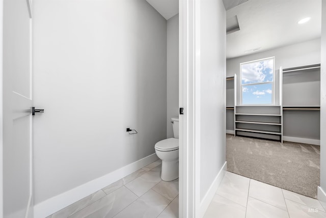 bathroom with toilet and tile patterned floors