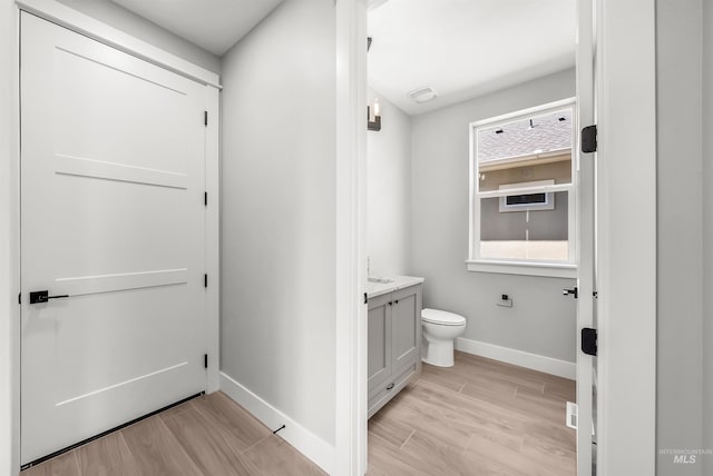 bathroom featuring toilet, vanity, and wood-type flooring