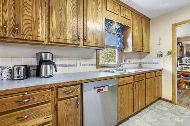 3242 S 2000 E, Wendell, ID 83355 - kitchen with a sink, tasteful backsplash, brown cabinetry, light countertops, and dishwasher