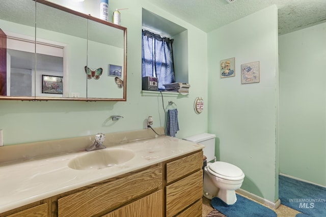 3242 S 2000 E, Wendell, ID 83355 - bathroom with baseboards, a textured ceiling, vanity, and toilet