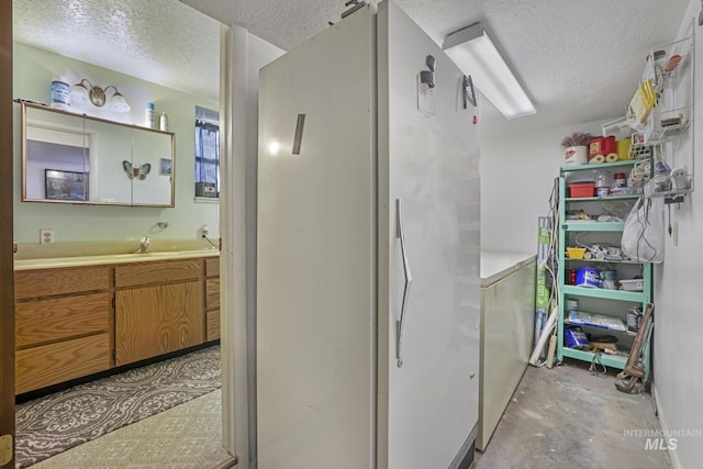3242 S 2000 E, Wendell, ID 83355 - interior space featuring brown cabinets, a textured ceiling, unfinished concrete flooring, and light countertops