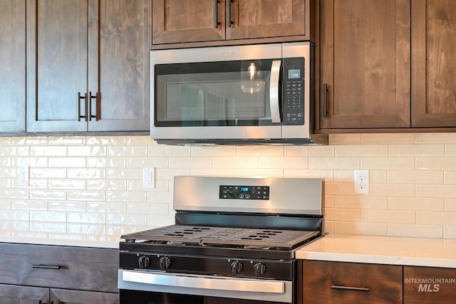 8900 W Snow Wolf Dr, Star, ID 83669 - kitchen featuring appliances with stainless steel finishes, decorative backsplash, light countertops, and dark brown cabinetry