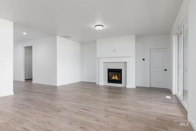8900 W Snow Wolf Dr, Star, ID 83669 - unfurnished living room featuring a glass covered fireplace, light wood-style floors, baseboards, and recessed lighting