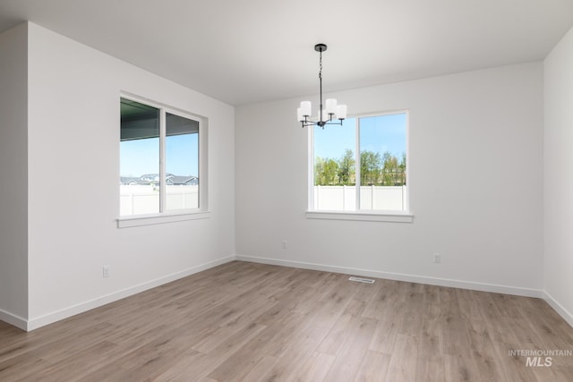 8900 W Snow Wolf Dr, Star, ID 83669 - spare room with a chandelier, light wood finished floors, and baseboards