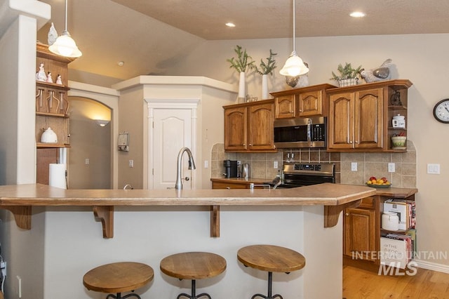 15697 Cupid Dr, Caldwell, ID 83607 - kitchen with a kitchen bar, lofted ceiling, hanging light fixtures, and appliances with stainless steel finishes
