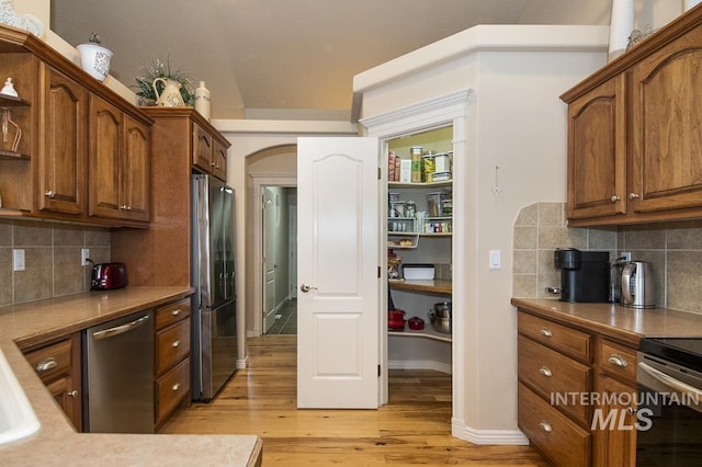 15697 Cupid Dr, Caldwell, ID 83607 - kitchen featuring decorative backsplash, stainless steel appliances, and light wood-type flooring