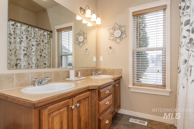 15697 Cupid Dr, Caldwell, ID 83607 - bathroom with vanity, a healthy amount of sunlight, and tasteful backsplash