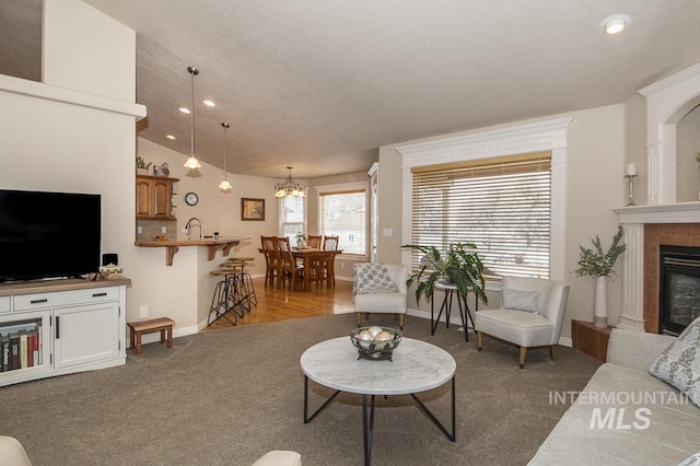 15697 Cupid Dr, Caldwell, ID 83607 - carpeted living room with a fireplace, vaulted ceiling, a notable chandelier, and sink