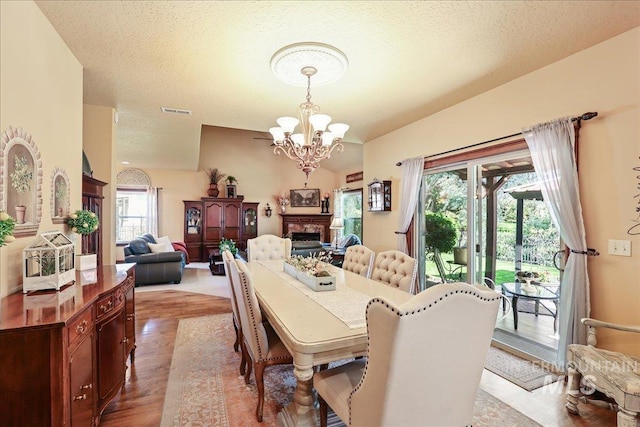 1404 Sandal Crk, Nampa, ID 83686 - dining space with a chandelier, wood finished floors, and a fireplace