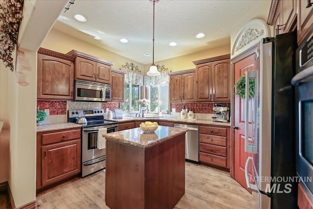 1404 Sandal Crk, Nampa, ID 83686 - kitchen with appliances with stainless steel finishes, a sink, a textured ceiling, a kitchen island, and backsplash