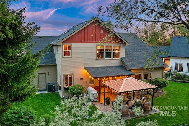 1404 Sandal Crk, Nampa, ID 83686 - back of property at dusk featuring a patio area, central AC, a lawn, and a gazebo