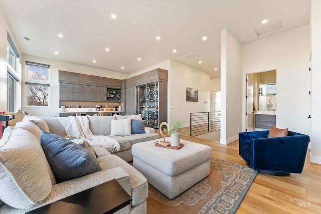 living room featuring indoor bar and light hardwood / wood-style flooring