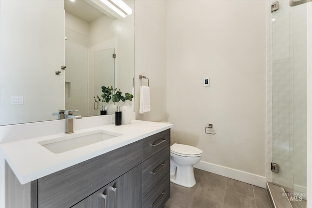 bathroom featuring toilet, a shower with shower door, and vanity