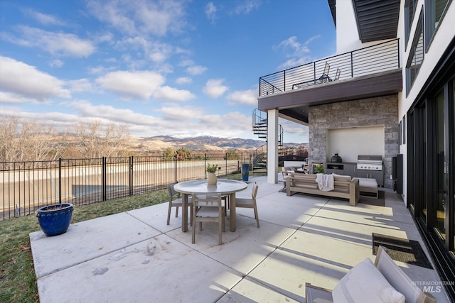 view of patio featuring a mountain view, outdoor lounge area, a balcony, and area for grilling