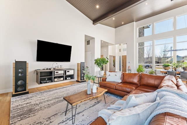 living room featuring wood ceiling, beamed ceiling, a high ceiling, and hardwood / wood-style floors