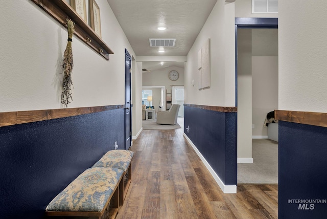 corridor featuring hardwood / wood-style floors, a textured ceiling, and lofted ceiling