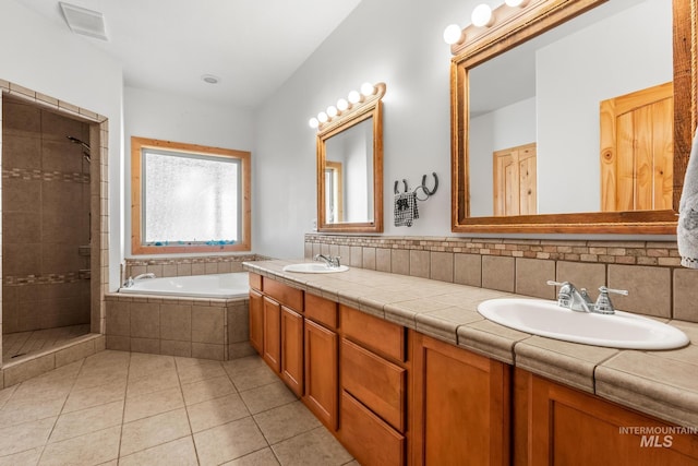 10389 Gamann Dr, Cascade, ID 83611 - full bathroom with double vanity, a garden tub, a shower stall, and tile patterned flooring