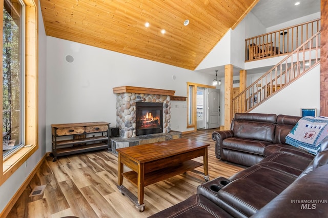 10389 Gamann Dr, Cascade, ID 83611 - living area with high vaulted ceiling, a stone fireplace, wood finished floors, stairway, and wood ceiling
