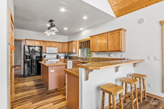 10389 Gamann Dr, Cascade, ID 83611 - kitchen featuring white appliances, wood finished floors, recessed lighting, a center island, and a peninsula