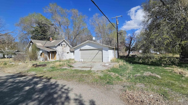 view of home's exterior with a detached garage and an outdoor structure