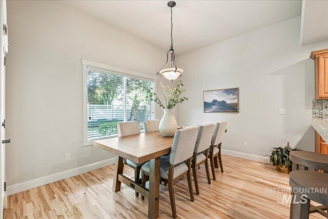 dining space with light wood finished floors and baseboards