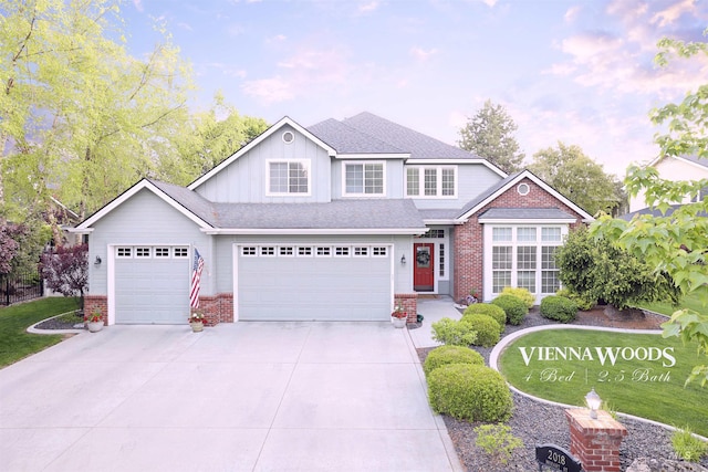 traditional-style home with brick siding, driveway, board and batten siding, and a garage