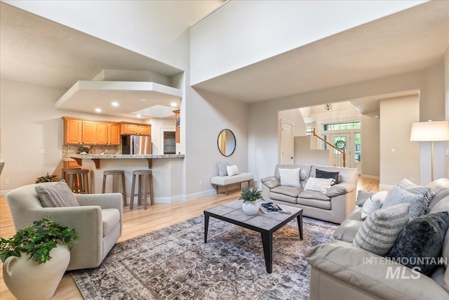 living room featuring light wood-style floors, baseboards, and recessed lighting