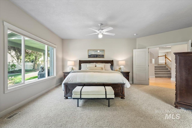 bedroom with light colored carpet, baseboards, and ceiling fan