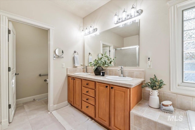 bathroom with a shower stall, decorative backsplash, double vanity, and tile patterned floors
