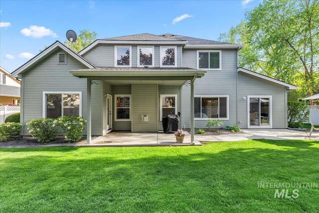 rear view of house with a patio and a lawn
