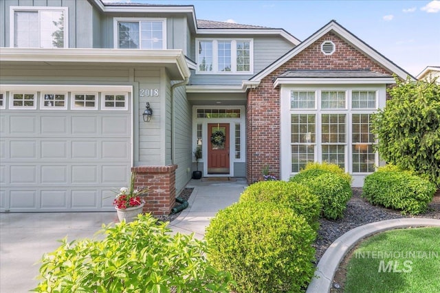 view of front of home with brick siding, an attached garage, and driveway