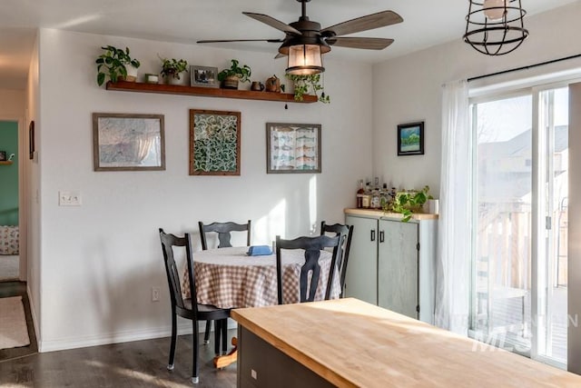 dining room featuring a ceiling fan, dark wood-style flooring, and baseboards