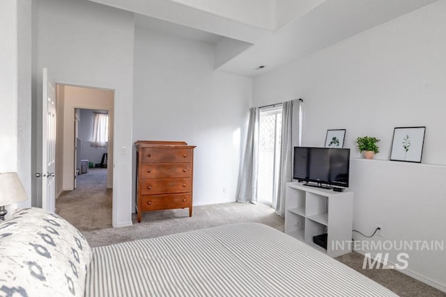 carpeted bedroom featuring a high ceiling