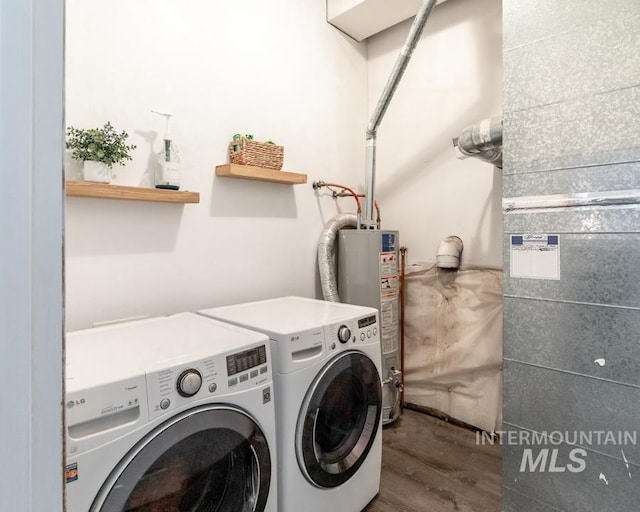 laundry area featuring water heater, laundry area, washing machine and dryer, and wood finished floors