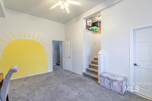 interior space with baseboards, carpet, and ceiling fan