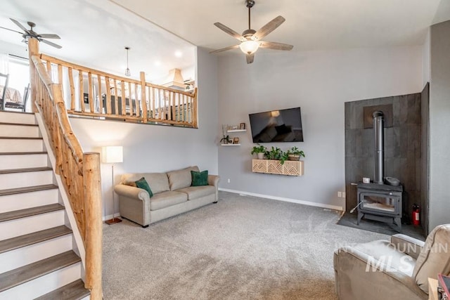 living area with a ceiling fan, stairs, carpet, and baseboards