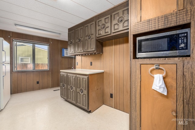 kitchen with white refrigerator and wooden walls