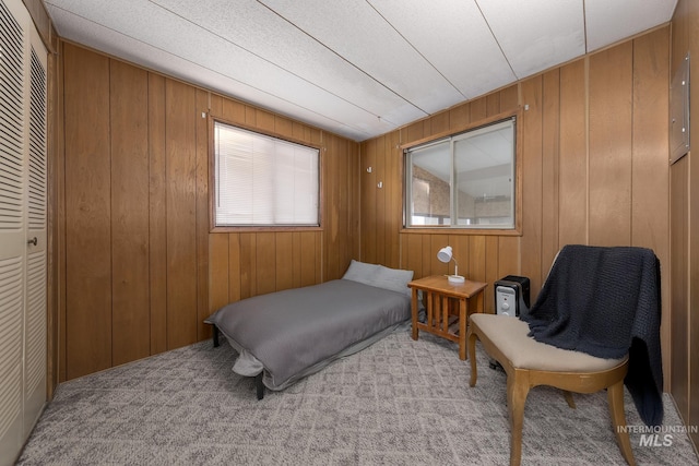 carpeted bedroom with wood walls