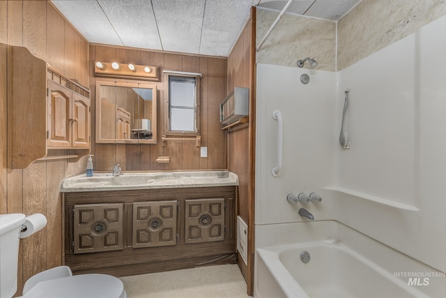 full bathroom with toilet, wood walls, shower / bathtub combination, and vanity