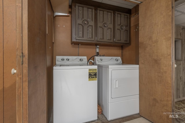 laundry area with washing machine and clothes dryer and cabinets